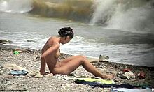 Mørkhåret naken jente går rundt naken på en strand