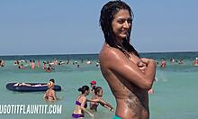 Piersiata brunetka z niesamowitym ciałem demonstruje swoją opaleniznę na plaży